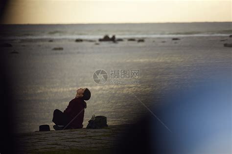 黄昏年轻女人坐在海边高清图片下载-正版图片502050620-摄图网