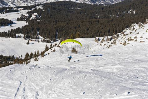 滑翔伞从雪地覆盖的斜坡上起降向高山高清图片下载-正版图片506499586-摄图网