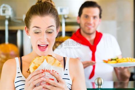 朋友或夫妇在美式快餐店吃快餐女服务员高清图片下载-正版图片502537952-摄图网