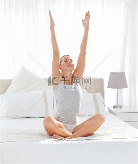 美丽的女人在她的床上练习瑜伽高清摄影大图-千库网