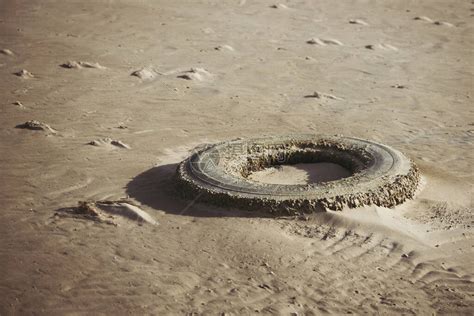 退潮后用沙子覆盖的旧汽车轮胎高清图片下载-正版图片503889271-摄图网