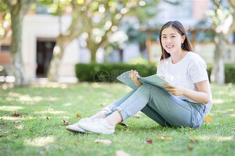 坐在校园草坪上看书的女学生高清图片下载-正版图片500635847-摄图网