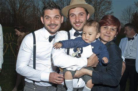 婚礼上新郎抱着男婴与家人和朋友们站在一起高清图片下载-正版图片501852304-摄图网