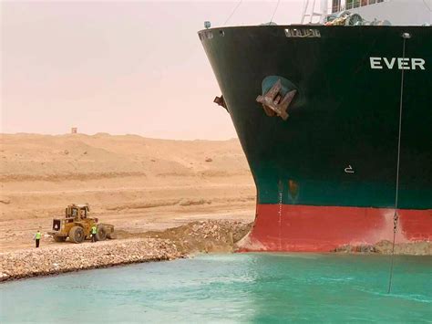 埃及运河搁浅巨轮旁“渺小”挖掘机的工人：面对梗图笑不起来