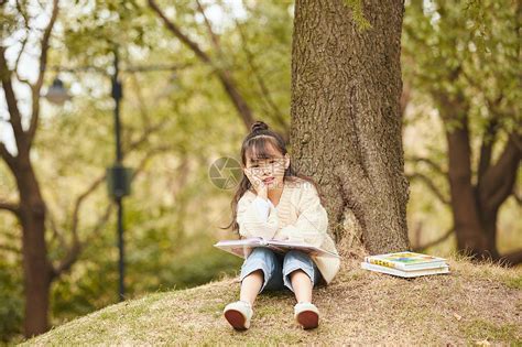 小女孩坐在树下读书高清图片下载-正版图片501482687-摄图网