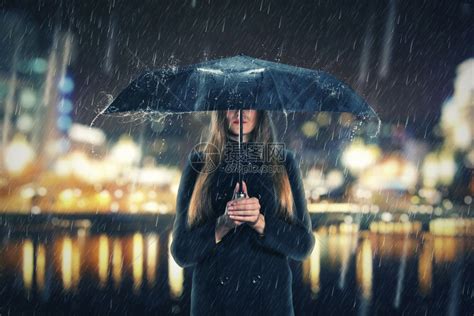 在下雨的晚上撑着黑色雨伞的女人高清图片下载-正版图片302496996-摄图网