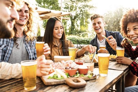 一群多种族的朋友在后院聚餐-多样化的年轻人坐在酒吧的桌子上举杯在啤酒厂酒吧花园-快乐时光，午餐休息和青年概念照片摄影图片_ID ...