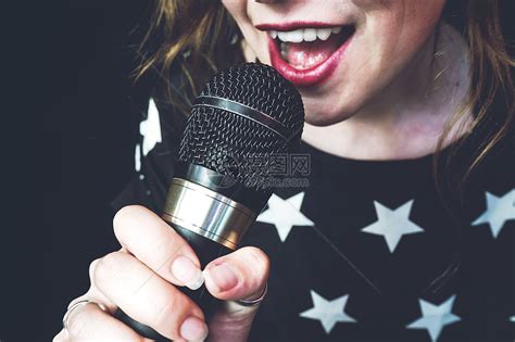 轻的女人用麦克风唱歌高清图片下载-正版图片300075959-摄图网