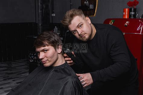 理发师 欧洲长相的男士理发师给客户剪黑发。高清摄影大图-千库网