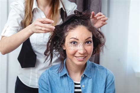 发型师为一个快乐的黑发女人制作卷发美发师在美发沙龙处理黑发女人的头高清图片下载-正版图片507284670-摄图网