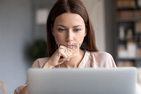 亲密体贴的女人摸着下巴，看着手提电脑屏幕高清摄影大图-千库网