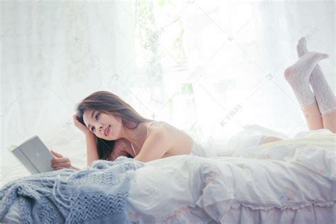 趴在床上看书的漂亮年轻女人高清摄影大图-千库网