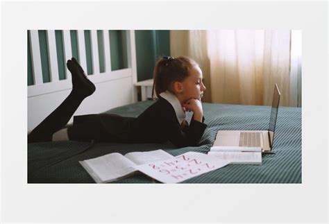 小女孩趴在床上看电脑实拍视频素材下载_mp4格式_熊猫办公