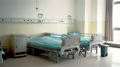 在一家医院里，医生们正在向一位躺在病床上的女病人询问并解释病情。(4 k的分辨率)视频素材_ID:VCG42N1127344389-VCG.COM