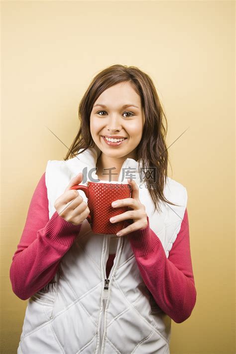 女人拿着杯子。高清摄影大图-千库网