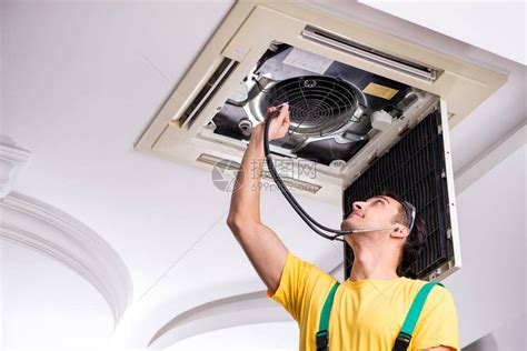 修理天花板空调机组的年轻修理工高清图片下载-正版图片506038737-摄图网
