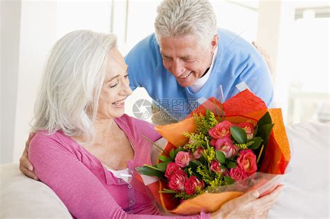 丈夫给妻子送花和微笑男性礼物生日浪漫女士情感沙发男人长椅客厅高清图片下载-正版图片320162509-摄图网