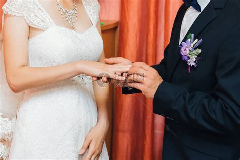 新郎将金婚戒戴在新娘的手指上传统的婚礼仪式和永远爱高清图片下载-正版图片506068721-摄图网