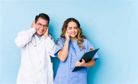 年轻医生夫妇在蓝色背景中举起双手孤高清图片下载-正版图片503834679-摄图网
