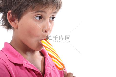 孩子在大自然中吃棒棒糖。高清摄影大图-千库网