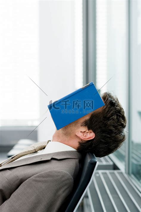 一个男人睡着的时候脸上贴着一本书高清摄影大图-千库网