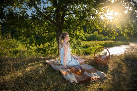 美丽的年轻女士坐在田野的大树下看着日落高清图片下载-正版图片304212897-摄图网