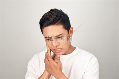 亚洲男人忧心忡忡的画像用手抚摸他的脸颊，感觉牙痛。高清摄影大图-千库网