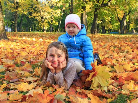 美丽的小女孩 在秋前秋叶的青树叶花圈中童年公园女孩叶子幸福橙子黄色孩子快乐森林高清图片下载-正版图片320940003-摄图网