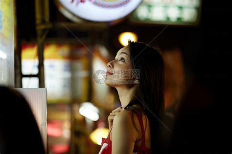 在夜市逛街的女游客抬头看高清图片下载-正版图片502057501-摄图网