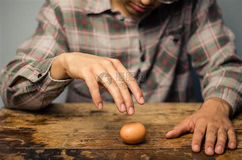 桌子上个鸡蛋的男人高清图片下载-正版图片300840785-摄图网