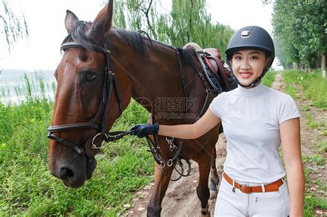 户外牵着马匹步行的漂亮女孩高清图片下载-正版图片507676262-摄图网