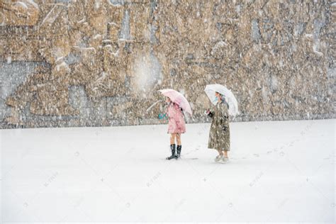 下雪天白天雪地上的女孩广场玩耍摄影图配图高清摄影大图-千库网