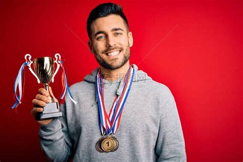 年轻英俊的成功男人拿着奖杯高清图片下载-正版图片504229201-摄图网
