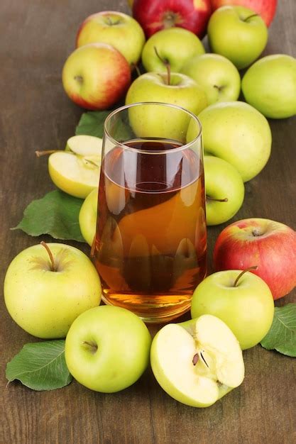 Útil jugo de manzana con manzanas alrededor en mesa de madera | Foto ...