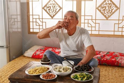 老年人坐在家里喝酒吃饭高清摄影大图-千库网