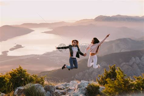 两个女孩在日落时跳上山去旅行高清图片下载-正版图片503586133-摄图网