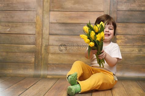 一个拿着一束黄色郁金香的小孩一个男孩拿着花瓶里的鲜花礼物给女假期女孩的礼物高清图片下载-正版图片506051308-摄图网