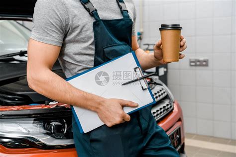 男汽车修理工带着记事本和咖啡在汽车修理店靠近汽高清图片下载-正版图片503131437-摄图网