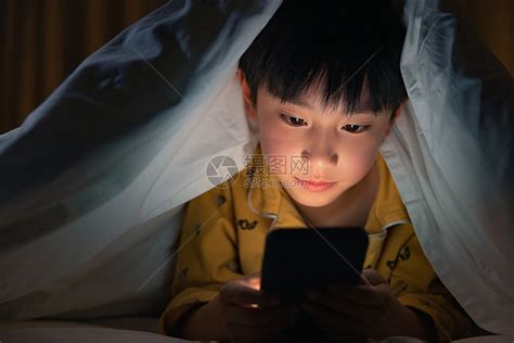 小男孩躲在被子下玩手机高清图片下载-正版图片501729975-摄图网