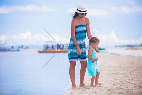 走在荒岛热带海滩上的小女孩和年轻母亲高清摄影大图-千库网