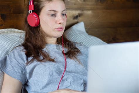 年轻女孩在床上听音乐看电影 高清图片下载-正版图片303483599-摄图网