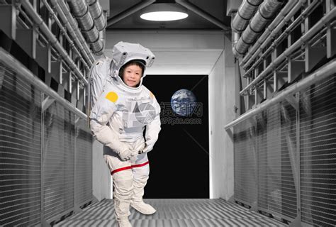 中镜头男孩在宇航员航天服服装摆姿势在基座上，背景是木镶板视频素材_ID:VCG42755-54-VCG.COM