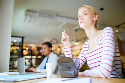 年轻妇女在自助餐厅吃午餐坐在窗前和吃食物的高清图片下载-正版图片505863999-摄图网