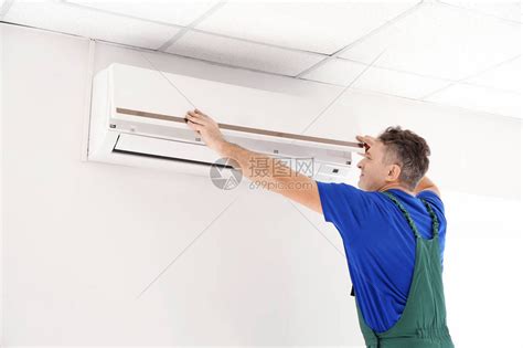 成熟的电工在室内修空调高清图片下载-正版图片505441304-摄图网