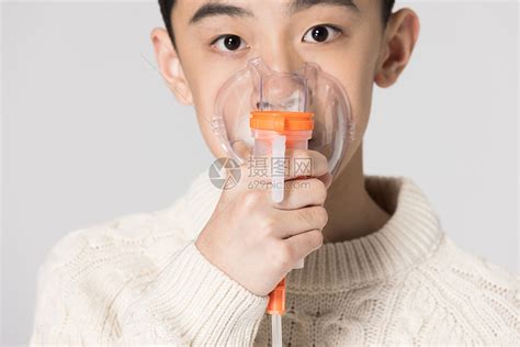 给病人戴氧气面罩的年轻医生高清摄影大图-千库网