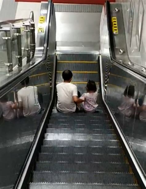 陆丰某地一小孩乘扶梯坐在梯级上，母亲对此危险视而不见，结果悲剧了_电梯安全_电梯资讯_新电梯网