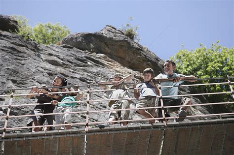 低角度的一对夫妇与三个孩子从桥上向下望向岩石高清图片下载-正版图片321861276-摄图网