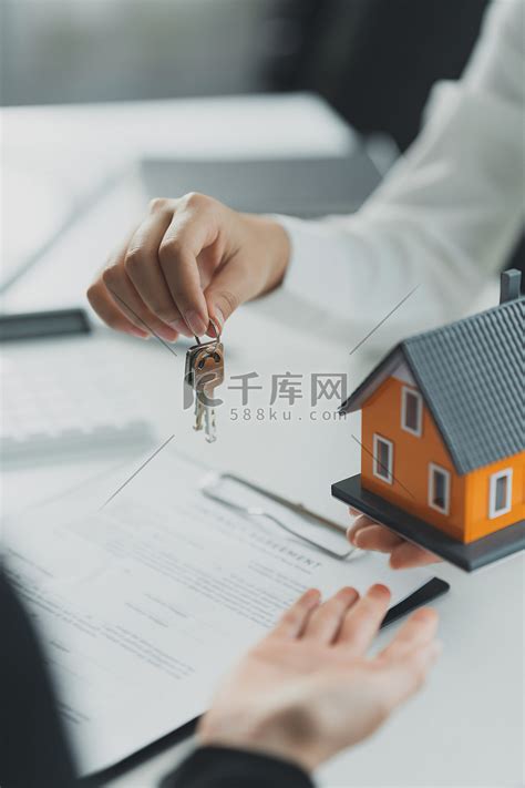 房地产经纪人或代理机构在签订协议合同后将房屋钥匙交给客户。高清摄影大图-千库网