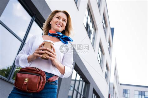 美女在街上用可支配咖啡杯行走的高清图片下载-正版图片503396546-摄图网