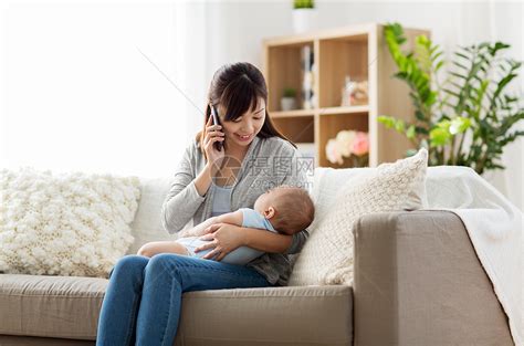 家庭,技术母亲的快乐的微笑的轻亚洲母亲与熟睡的婴儿打电话家里的智能手机母亲带着婴儿家里打电话给智能手机母亲高清图片下载-正版图片 ...